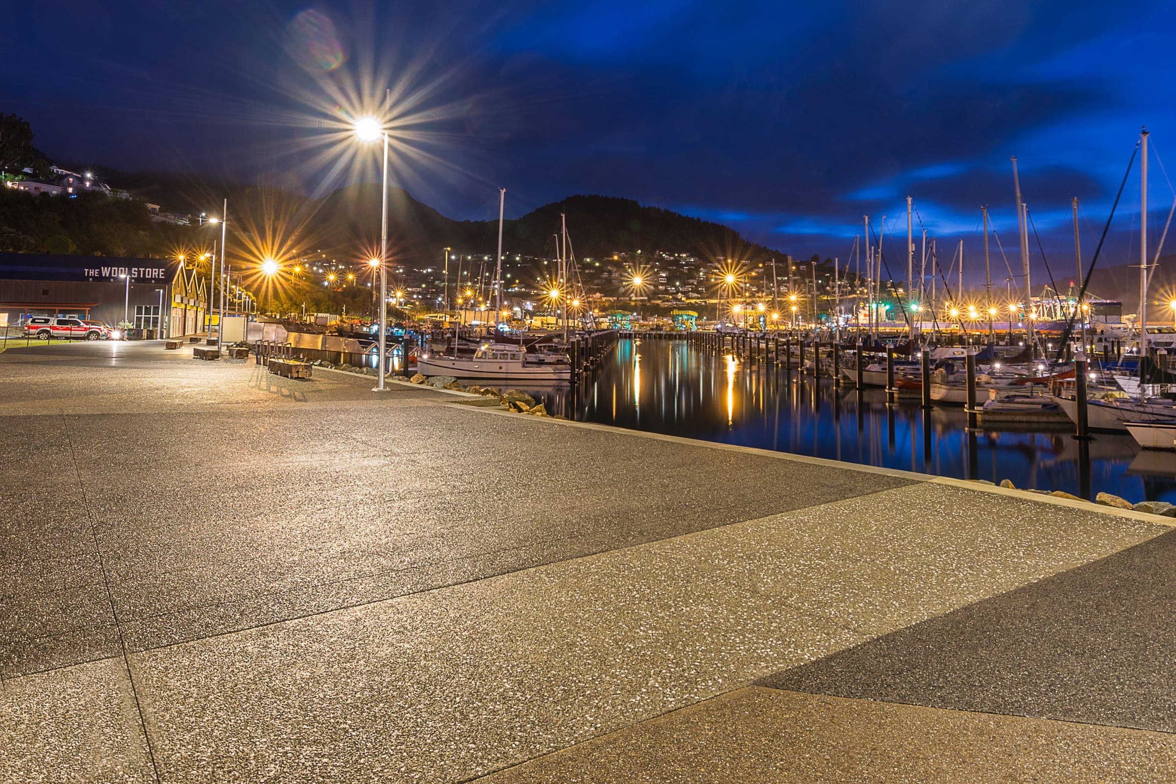 Two-tone exposed aggregate lit along the waterfront at night.