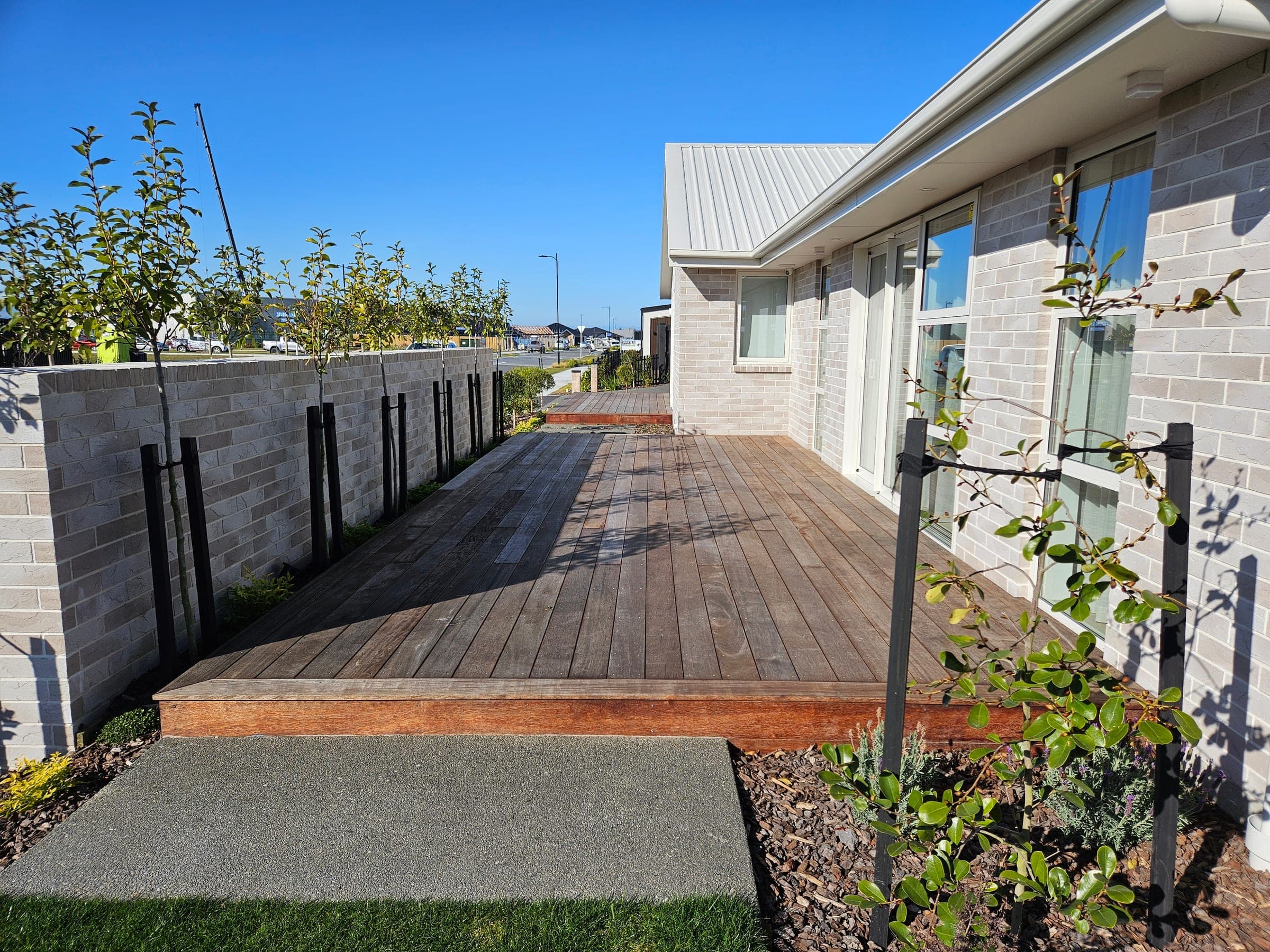 Hardwood decking by Landscape Brothers meeting our concrete and paver work.