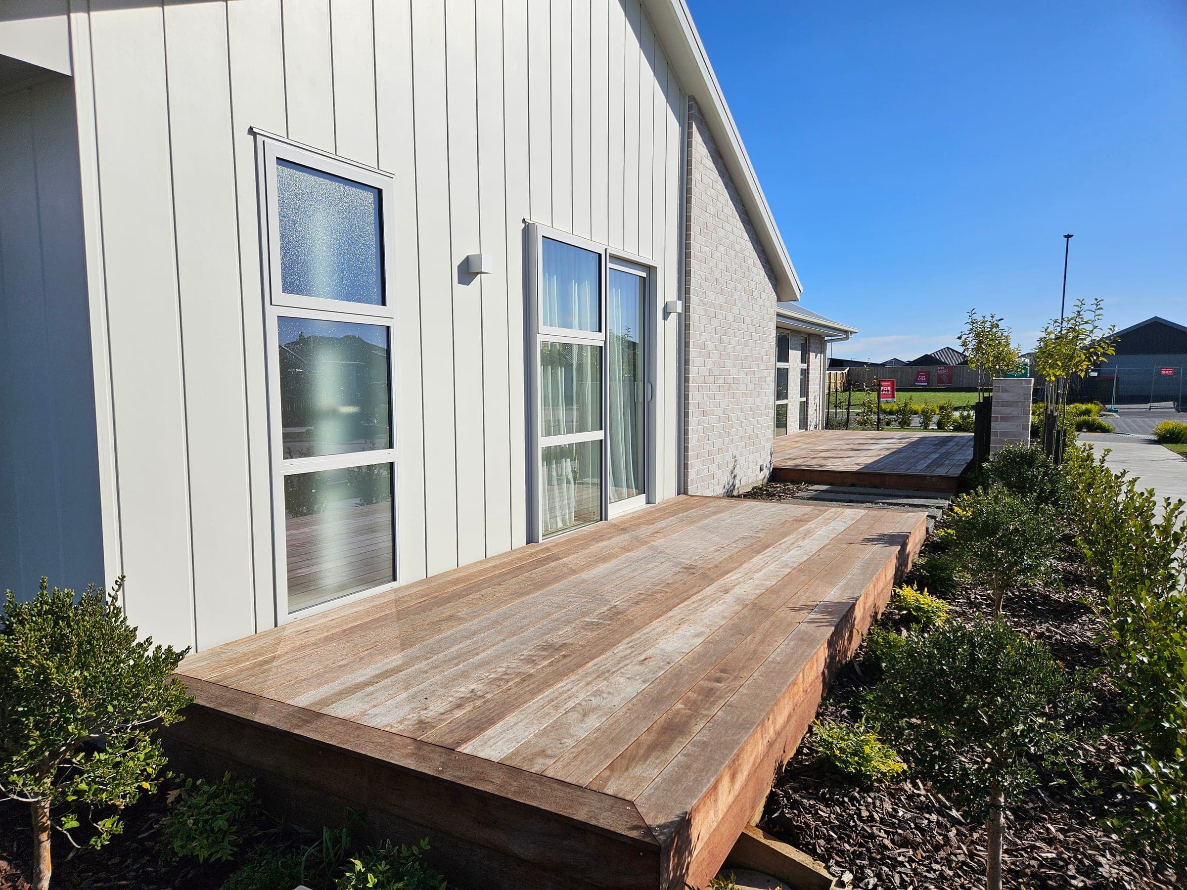 Timber decking wrapping the show home — the landscaping side, by our brother company.
